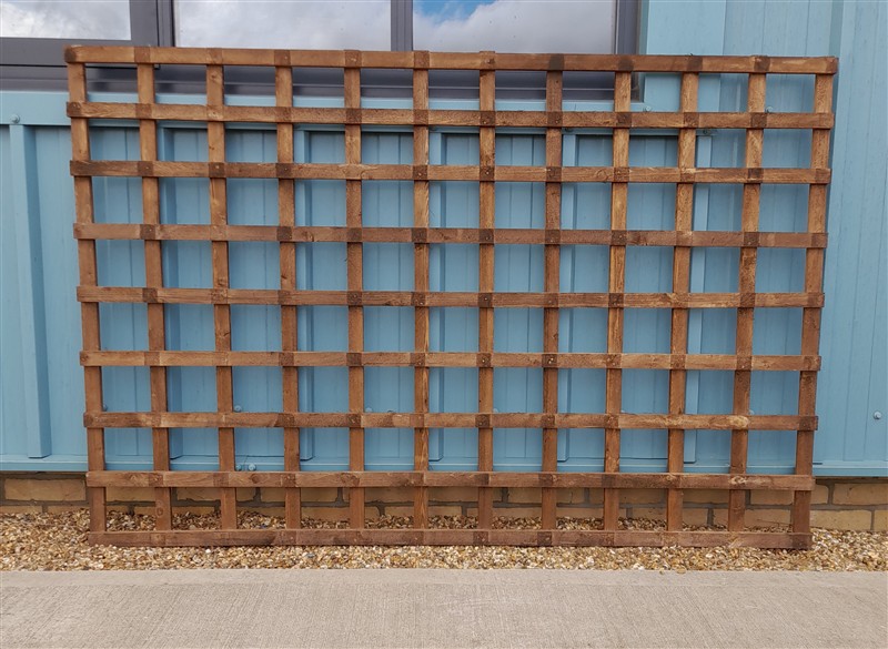 Rustic wooden trellis against a pale blue wall