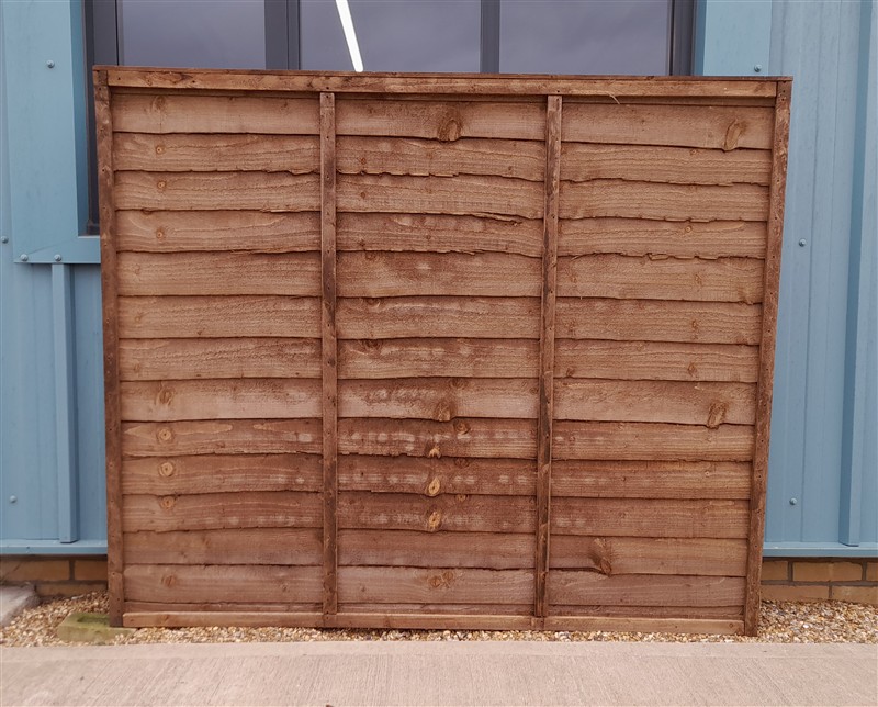 Wooden fence panel leaning against blue building wall