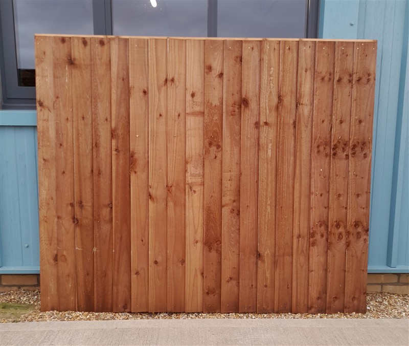 Wooden fence panel leaning against blue building