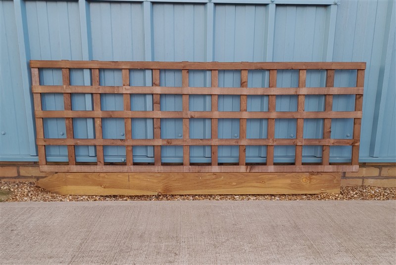 Wooden trellis panel leaning against blue corrugated wall