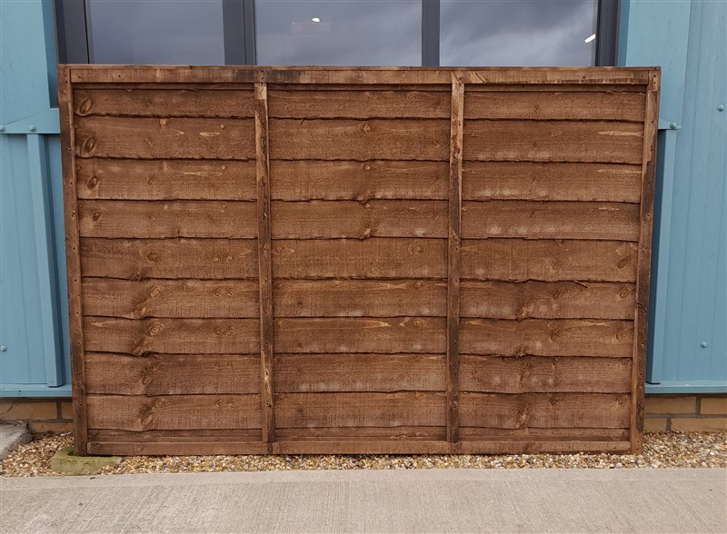 Wooden fence panel leaning against blue building