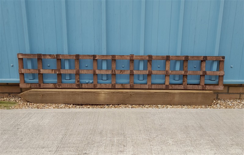 Rustic wooden lattice planter against blue metal wall