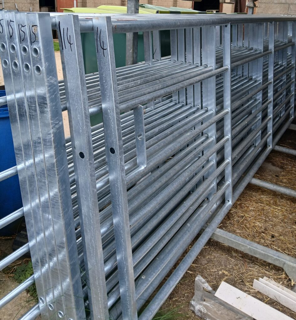 Stacked galvanised steel livestock gates in farmyard