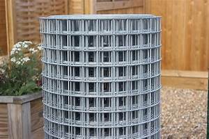 Roll of galvanised welded wire mesh beside garden fence