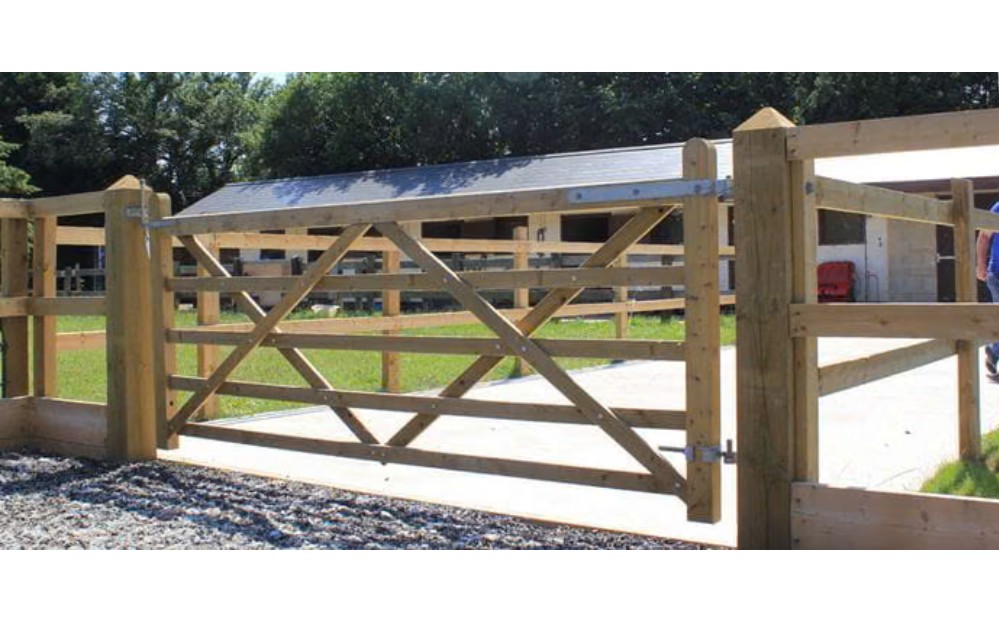 Wooden five-bar field gate at a rural property entrance